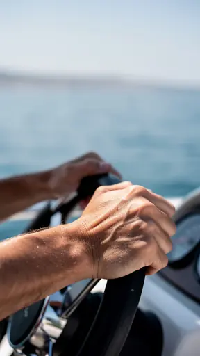 Close-up photo of hands on a boat steering wheel, natural daylight, shallow depth of field, calm sea in background, realistic, no text, no logo
